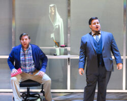 Nicholas Huff (left) as Fabian, an aspiring writer who yearns for adventure, and Rafael Porto (right) as Putnam, his unpleasant boss. Behind is Brennan Blankenship as Brittomara, a shape-shifting devil in the world premiere of "If I Were You" by Jake Heggie and Gene Scheer, presented by Merola Opera Program, August 1-6, 2019 at the Herbst Theatre in San Francisco.