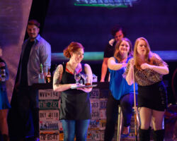Pictured: Cara Collins (left) as Brittomara, a shape-shifting devil appearing here as a bartender, Esther Tonea as Diana, and Edith Grossman as Rachel in the world premiere of "If I Were You" by Jake Heggie and Gene Scheer, presented by Merola Opera Program, August 1-6 at the Herbst Theatre in San Francisco.